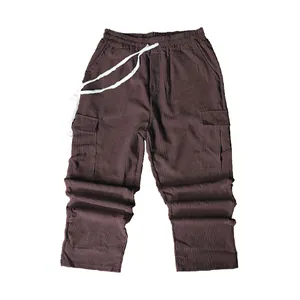 Close-up of brown corduroy cargo pants with multi-pocket design and white drawstring waist