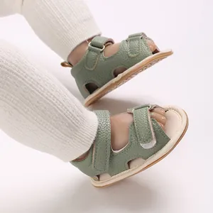 Close-up van groene babysandalen met zachte zool en klittenbandsluiting op babyvoetjes