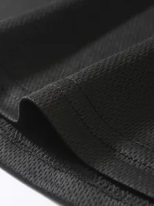 Dettaglio ravvicinato del tessuto mesh nero traspirante e cuciture di una canotta uomo