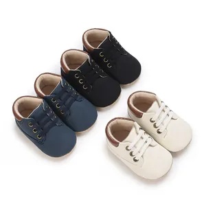 Close-up of soft-sole baby pre-walker shoes in black, navy blue and cream white