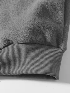 Detailaufnahme des grauen Fleece-Stoffs und des gerippten Bündchens an einem Herren-Sweatshirt