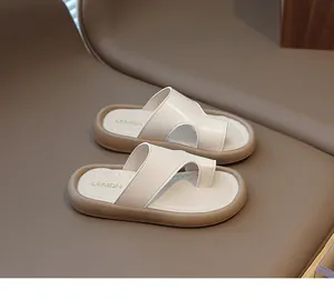 Sandalias de dedo minimalistas para niños en beige con una suela marrón muy gruesa.