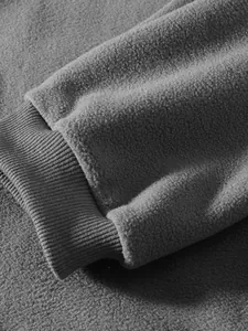 Nahaufnahme der gerippten Manschette und der grauen Polarfleece-Textur am Herren-Sweatshirt.
