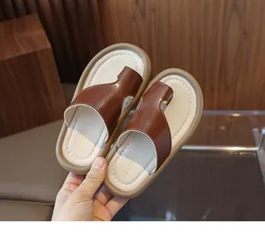 Vista detallada de las sandalias de dedo marrones para niños con el logo de Lemon