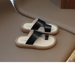 Primer plano de elegantes sandalias de playa para niños en cuero negro con suela gruesa