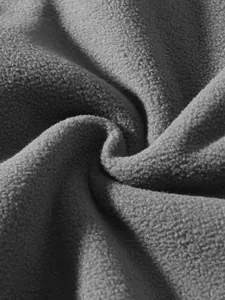 Detailaufnahme der weichen und warmen Textur des grauen Polar-Fleece-Stoffs für Herren