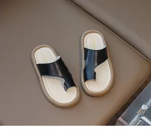 Vista detallada de las elegantes sandalias de dedo para niños en color negro y beige con suela