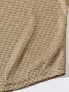 Dettaglio macro della trama in maglia traspirante di una canotta sportiva kaki da uomo