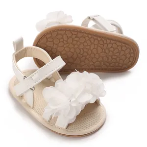 Vista detallada de sandalias blancas con flores para bebé y suela de goma antideslizante