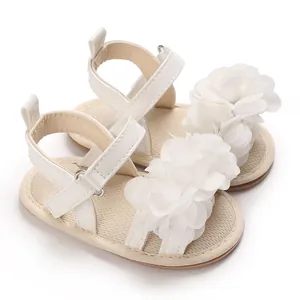 Vista detallada de las sandalias blancas para niñas con flores de tela decorativas.