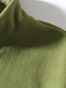 Nahaufnahme von weichem olivgrünem Polarfleece-Stoff mit präzisen Kragennähten