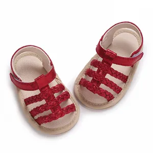 Detailopname van rode gevlochten babyzomersandalen met zachte rubberen antislipzolen
