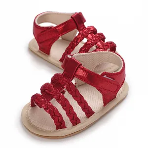 Detailweergave van rode gevlochten babysandalen met glitter en klittenband