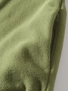 Detailaufnahme des weichen olivgrünen Polarfleece-Stoffs und der Taschenöffnung