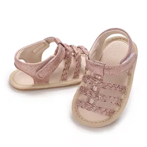Close-up van roze glitter baby sandalen gevlochten met zachte rubberen zool