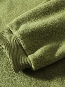 Nahaufnahme der Textur des olivgrünen Polarfleece-Stoffs und Rippbündchendetails