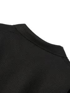 Dettaglio ravvicinato di una giacca da uomo in maglia a nido d'ape nera con colletto
