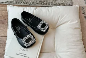 Detailopname van elegante zwarte ballerina's met vierkante neus en fonkelende strass-gesp
