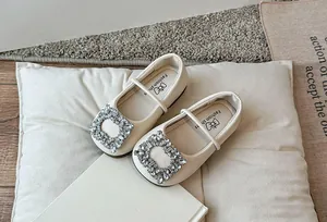 Gedetailleerd overzicht van elegante crème ballerina's met sprankelende strass gesp.