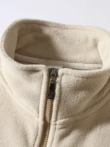 Detailansicht einer beigefarbenen Herren-Fleecejacke mit Stehkragen und Reißverschluss.