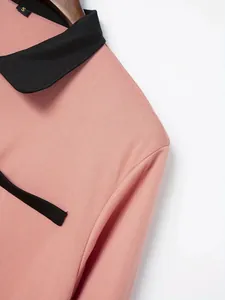 Detailopname van roze poloshirt voor heren met zwarte revers en piqué-stofstructuur