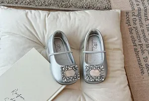Detailweergave van elegante zilveren Mary Jane-flats met een fonkelende strass-gesp.