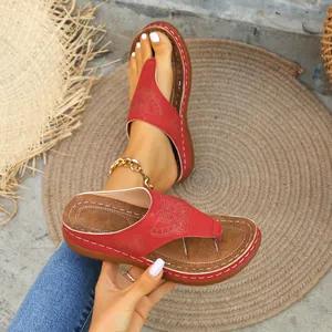 Primer plano de elegantes chanclas rojas con plataforma para mujer y estampado de mariposa