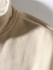 Makrodetail eines beigefarbenen Herren-Fleece-Sweatshirts mit Stehkragen und feiner Textur
