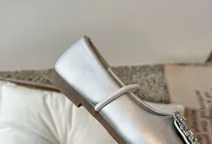 Detail van zilveren ballerina's met vierkante neus en fonkelende strass-gesp