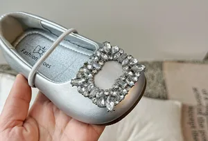 Detailweergave van zilveren Mary Jane-ballerina's met kristallen gesp
