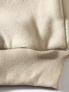 Nahaufnahme von beigem Fleece-Stoff und dem gerippten Bündchen am Herren-Sweatshirt