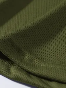 Dettaglio macro del tessuto a rete traspirante verde oliva e cuciture per gilet
