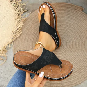 Primer plano de chanclas de plataforma negras para mujer con elegantes motivos de mariposa