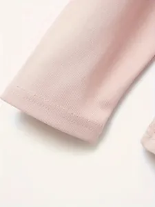 Detailopname van de roze textuur en stiksels op een polo met lange mouwen