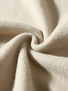Nahaufnahme der weichen, cremefarbenen Polar-Fleece-Stoffstruktur mit Materialdetails