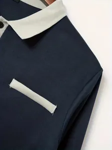 Gedetailleerd macrobeeld van de lichtgrijze contrastkraag en neppak op een donkerblauw poloshirt