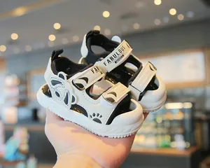 Vista dettagliata dei sandali da neonato neri e bianchi con design a panda e strap