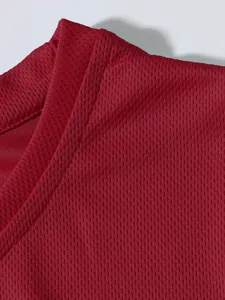 Macro del tessuto a rete rossa e dettagli delle cuciture di una canotta sportiva