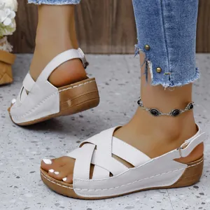 Vue détaillée des sandales compensées blanches avec brides croisées et boucle au talon.