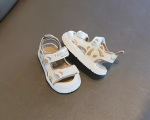 Vista dettagliata di sandali color crema per bambini con suola morbida e motivi panda