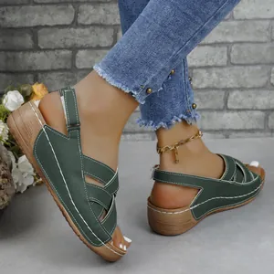 Close-up of women's dark green wedge sandals with thick soles and white stitching