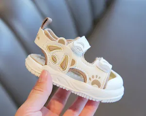 Primo piano di sandali bianchi per bambini con simpatici motivi panda e cinturini in velcro regolabili