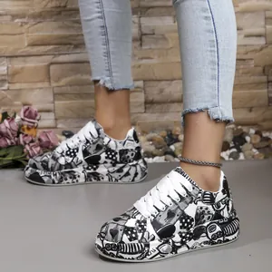 Detailed view of women's graffiti print sneakers with thick soles and white laces