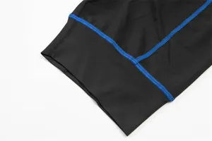 High-quality close-up showing blue flatlock stitching on black cycling shorts fabric detail