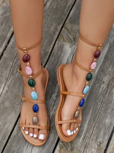 Bohemian tan flat sandals for women featuring unique colorful stone T-strap design