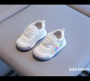 Makro-Detail von weißen atmungsaktiven Mesh-Babyschuhen mit hübschen Pastellfarben und Riemen