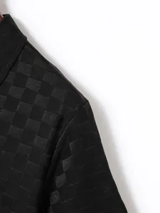 Close-up view of black jacquard checkered fabric texture on a men's casual Polo shirt.