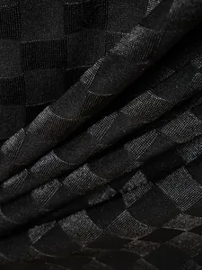 Macro detail of black checkered jacquard fabric texture on a men's sports polo shirt