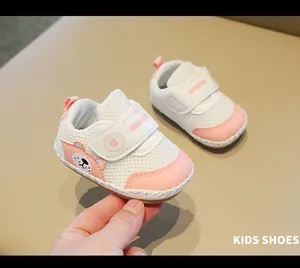 Dettaglio delle scarpe da passeggio per neonati in rete rosa e bianca con orsetto