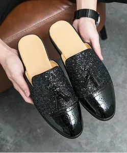 Detailansicht der schwarzen Pailletten-Loafer ohne Ferse mit Quasten und Brogue-Spitze.